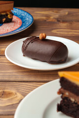 Delicious chocolate cake in white plate on wooden table background