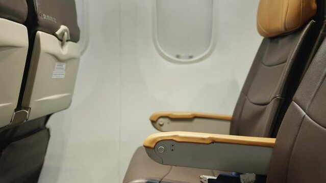 The plane Long and boring flight. Silence disappearing, Tourism and bustle are returning. Row of brown seats Interior from empty modern luxury intercontinental passenger plane with windows background.