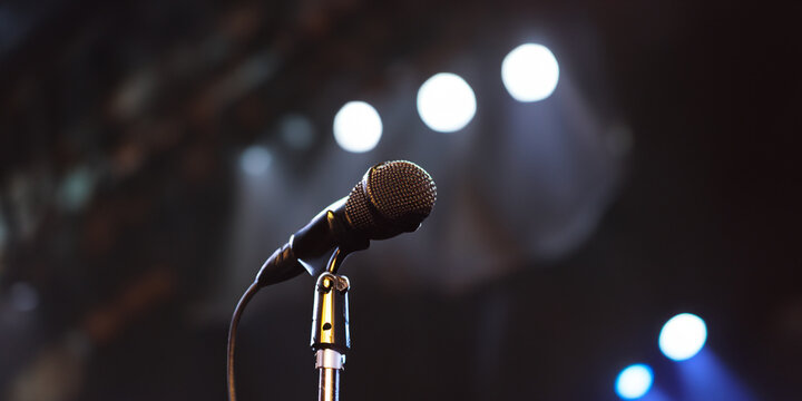 Microphone with stage and lights in the background. Concept of freedom of speech and expression. Right to speak, equality for all. Announcements and speeches. Music and singer.