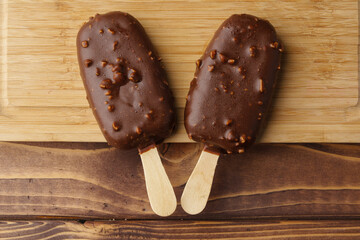 Chocolate cake pops ice creams on wooden board close up