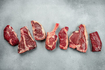 set of various uncooked stakes t bone tomahawk sirloin ribeye beef on a light background. banner,...