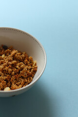 Rolled oats in wooden bowl and ears of wheat on blue background. Table top view. Healthy eating, healthy lifestyle, gluten free diet concept
