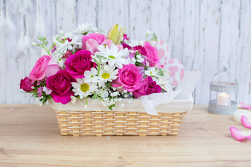 bouquet of pink  roses, lilies and 
daisies in a basket