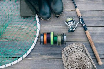 Fishing tackle for fishing fish. Spinning in a composition with accessories for fishing on a wooden background on the table.