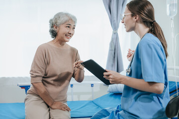 Obraz premium Young beautiful smiling doctor nurse caring to help happy senior grandmother helping old patients in rehabilitation at elderly health checkup