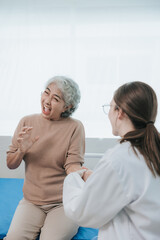 Obraz premium Young beautiful smiling doctor nurse caring to help happy senior grandmother helping old patients in rehabilitation at elderly health checkup