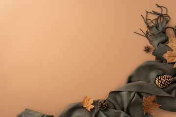 Autumn-themed fashion concept. Top-view perspective of sophisticated gray scarf, golden maple...