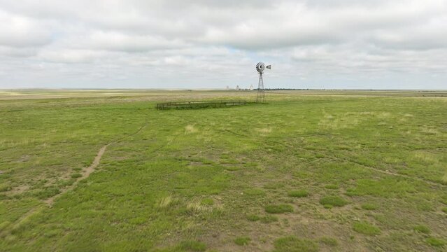 Grasslands And Cattle Wind Pump Fly By View.