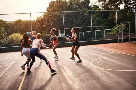 Trying to get through. Cropped shot of a diverse group of sportswomen playing a competitive game of basketball together during the day.