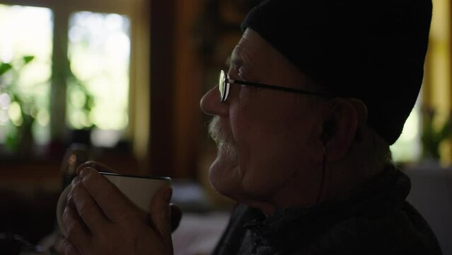 Old man in a wheelchair watching tv in the livingroom at home