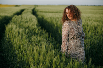 Curly girl standing on green field