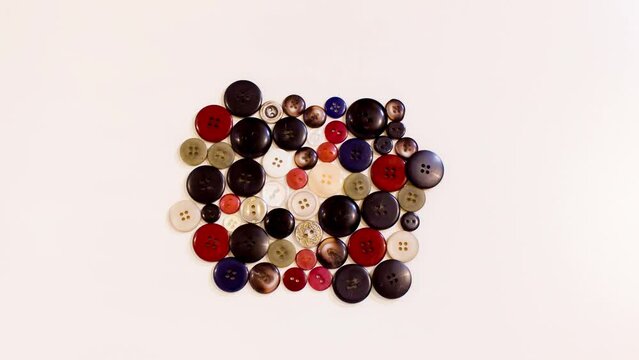 Colored sewing buttons appear in stop motion