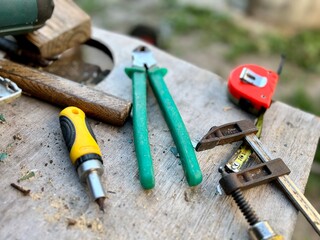 Desk of a carpenter with different tools on a wooden background.