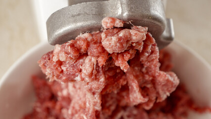 Closeup of making minced meat in electric grinder at home. Cooking at home, kitchen appliance,...