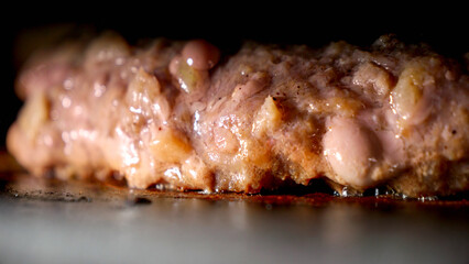 Closeup of cooking beef burgers in electric grill. Cooking at home, kitchen appliance, healthy nutrition, hamburger ingredients.