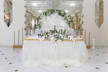 Wedding table of the bride and groom restaurant. Decorated in white.