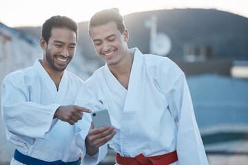 Men, martial arts or karate class with phone, thinking or pointing at training video on web for development. Fight workout partnership, smartphone or meme with focus for exercise, coaching or sports © Wesley JvR/peopleimages.com