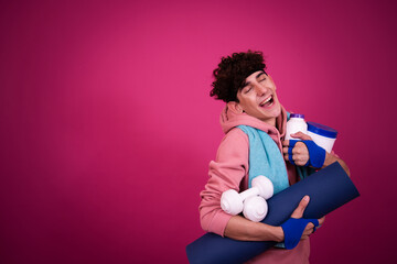 Funny sportsman and retro style. The guy poses on a pink background.