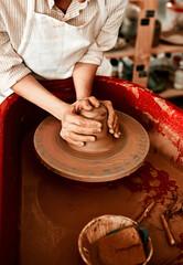 Clay is one of the easiest mediums to work with. Cropped shot of an unrecognizable woman molding clay on a pottery wheel.