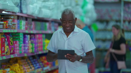 One Black Senior Manager Checking Grocery Store Inventory with Tablet, African American Business Owner Leveraging Modern Technology