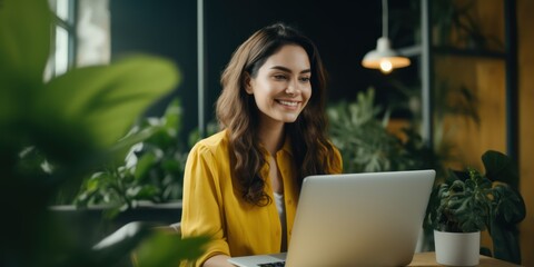 young beautiful joyful woman smiling while working with laptop