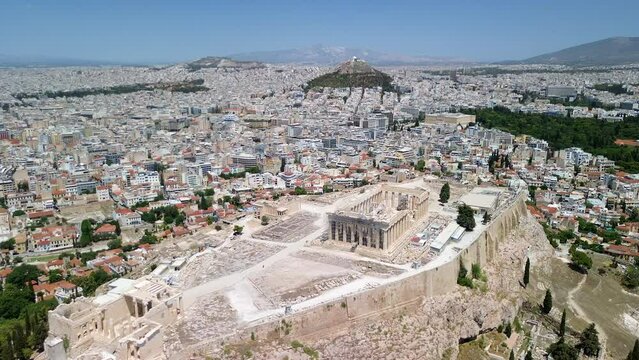 Aerial drone video or film of the Acropolis with the Parthenon in Athens, Greece. No people. Construction and restoration works underway. Clear summer day. High quality 4K film