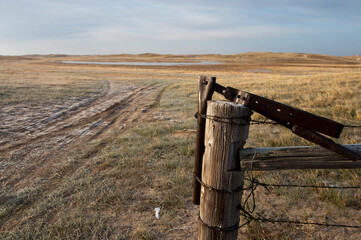 Fence, post and gate latch in the countryside of the Nebraska Sandhills, USA; Sandhills, Nebraska, United States of America