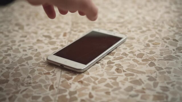 A phone falls to the floor and is raised