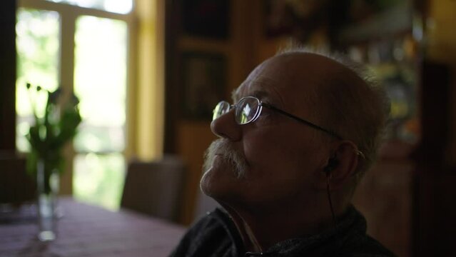Old man in a wheelchair watching tv in the livingroom at home