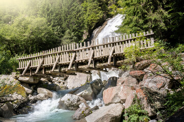 wooden bridge that crosses the amola waterfall in the nambrone valley in trentino