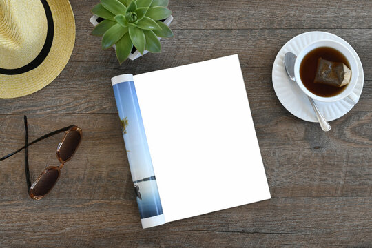 An open magazine laying on a table or desk with a white blank page for mock up.
