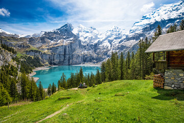 Amazing tourquise Oeschinnensee with waterfalls, wooden chalet and Swiss Alps, Berner Oberland,...