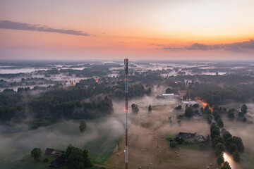 Misty sunset over the small village from above