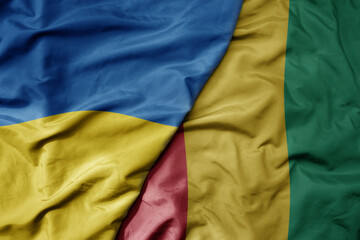 big waving national colorful flag of ukraine and national flag of guinea .