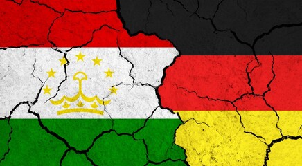Flags of Tajikistan and Germany on cracked surface - politics, relationship concept