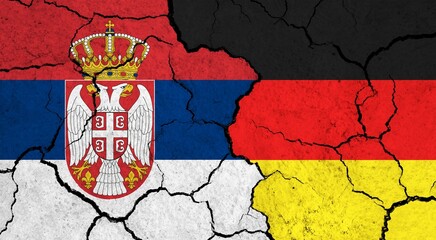 Flags of Serbia and Germany on cracked surface - politics, relationship concept