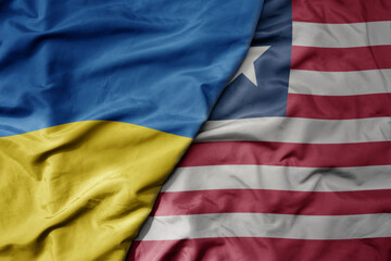 Obraz premium big waving national colorful flag of ukraine and national flag of liberia .