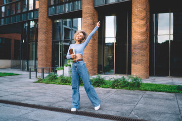Happy woman with books standing at building entrance