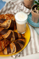 Chocolate croissants or croissant with nut crumbs on a plate. Delicious breakfast on the table. Tasty sweet baking dessert for coffee. Food background. Fresh buttery croissants rolls