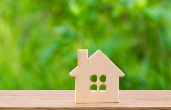 Small Wooden House On A Green Background