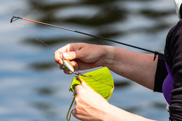 female hand with rod and bait
