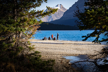 Family having a beachfront dinner overlooking a blue glacier fed lake in Banff National Park Canada.