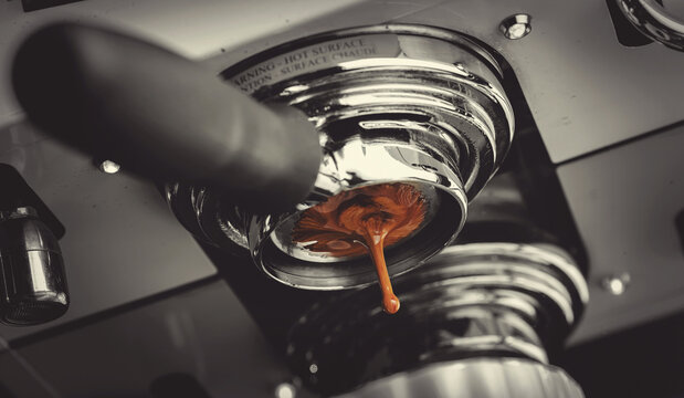 Macro photo Process professional espresso pouring from coffee machine in cafe, warm toning