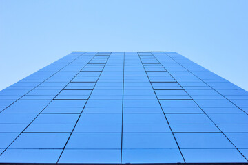 Fototapeta na wymiar A modern building seen from below, reflecting the sky