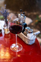 glass with red wine on red table in restaurant
