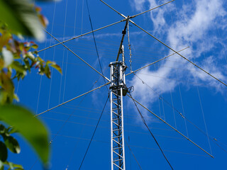 Fototapeta premium A close-up shot of a tall ham radio antenna against a blue sky.