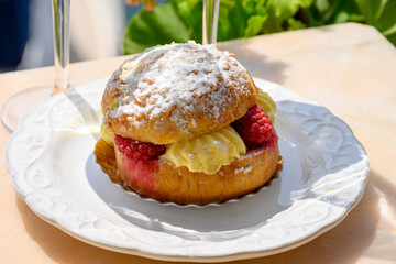 Tarte tropezienne or La Tarte de Saint-Tropez - dessert pastry consisting of filled brioche with cream and fresh berries served outdoor