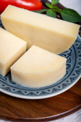 Italian cheese, Provolone dolce cow cheese from Cremona served with olive bread and tomatoes close up