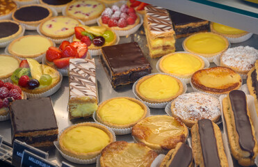 French fresh baked sweet pastry with chocolate, fresh fruits and berries in confectionery shop close up