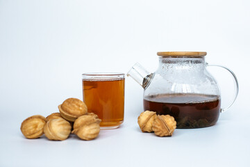 Teapot with cookies on white background